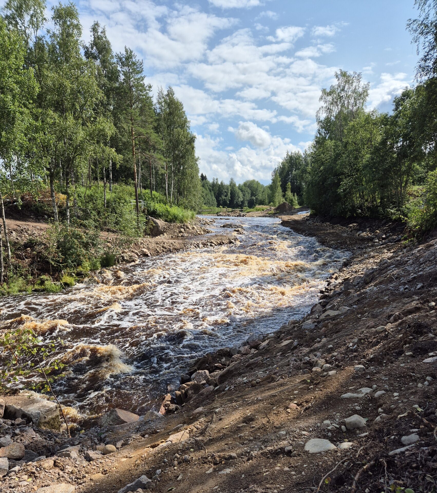 Jyllinkosken pato on purettu ja vesi virtaa. Joen ympärillä rakennustyömaata.